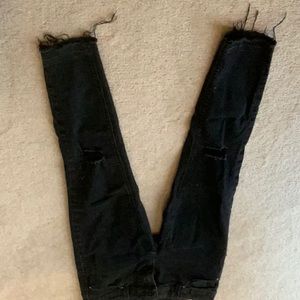 Gone!!!
Skinny black jeans with raw hem. Holes below knee